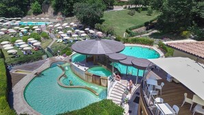 A large outdoor swimming pool area with multiple pools and a deck area with seating. - Relais il Ciliegio (Sorano)