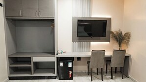 A modern room with a built-in desk, a flat-screen TV, a wardrobe, and a trash bin. - MD Recanto Iguaçu (Foz do Iguacu)