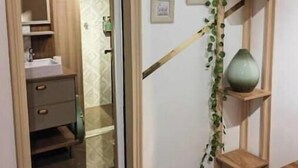 Une salle de bain avec un meuble-lavabo en bois, un miroir et un espace douche.