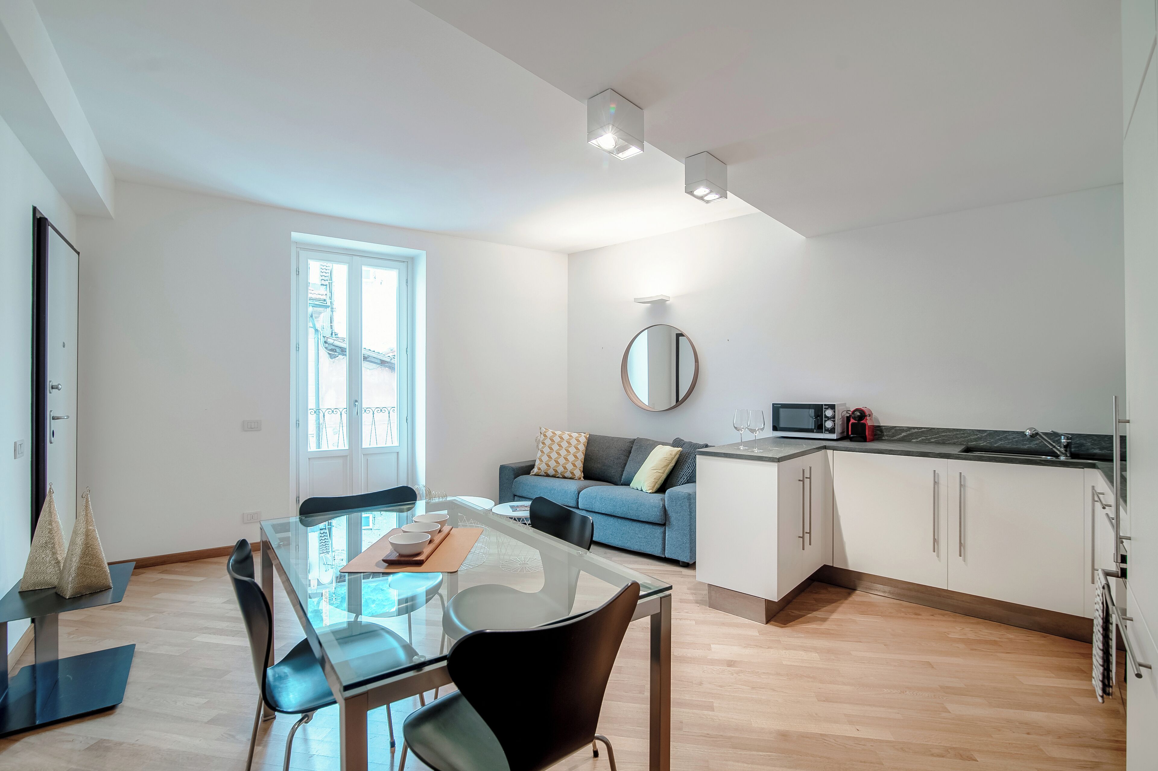 A modern apartment with a dining area, kitchen, and living space.