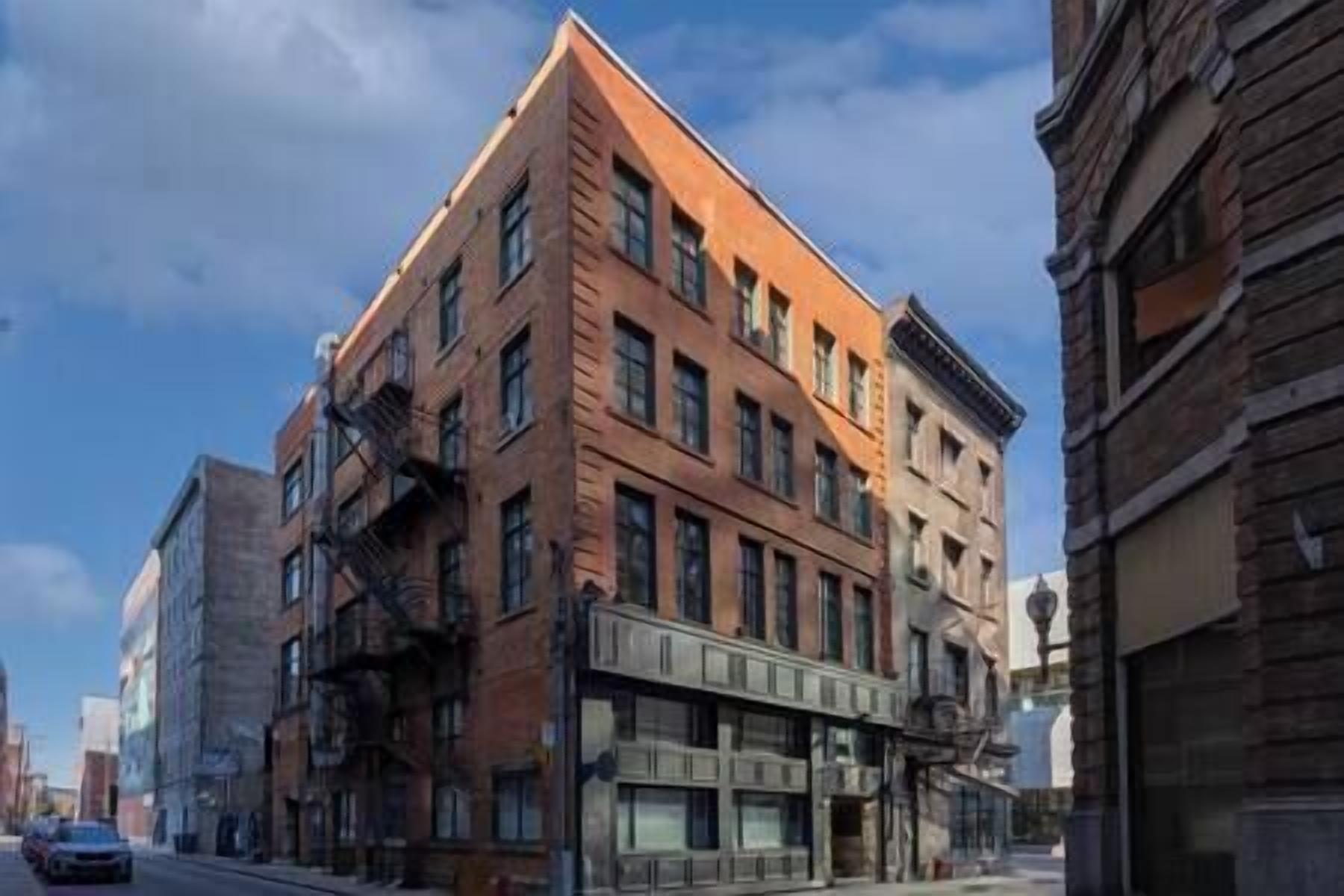 A multi-story building with a brick facade, large windows, and a fire escape.