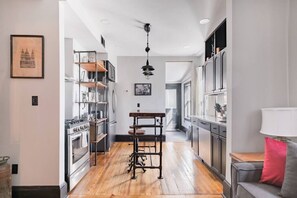 Une cuisine moderne avec un plancher en bois, des appareils électroménagers en acier inoxydable et un îlot central.