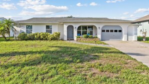 A single-story house with a garage, a front porch, and a well-maintained lawn. - Spacious 4-bedroom house with 2 master suites in lovely Port Charlotte. (Port Charlotte)