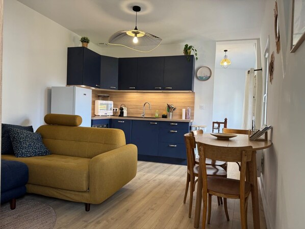 A compact living space with a sofa, dining table, and kitchen area. - Apartment with Wifi near city center (Trouville-sur-Mer)