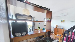 Cocina compacta con lavamanos, tostadora y encimera de madera.