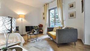 A modern living room with a sofa, a coffee table, a TV, and a lamp.