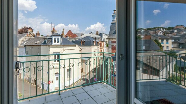 A balcony with a clear view of surrounding buildings and a blue sky. - Bourgeois apartment (Trouville-sur-Mer)