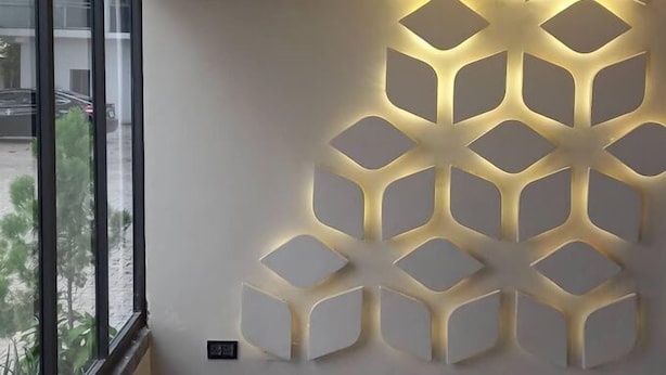 A wall with a geometric light fixture design.