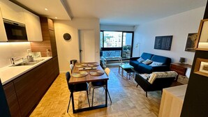 A modern apartment with a kitchen, dining area, and living room.