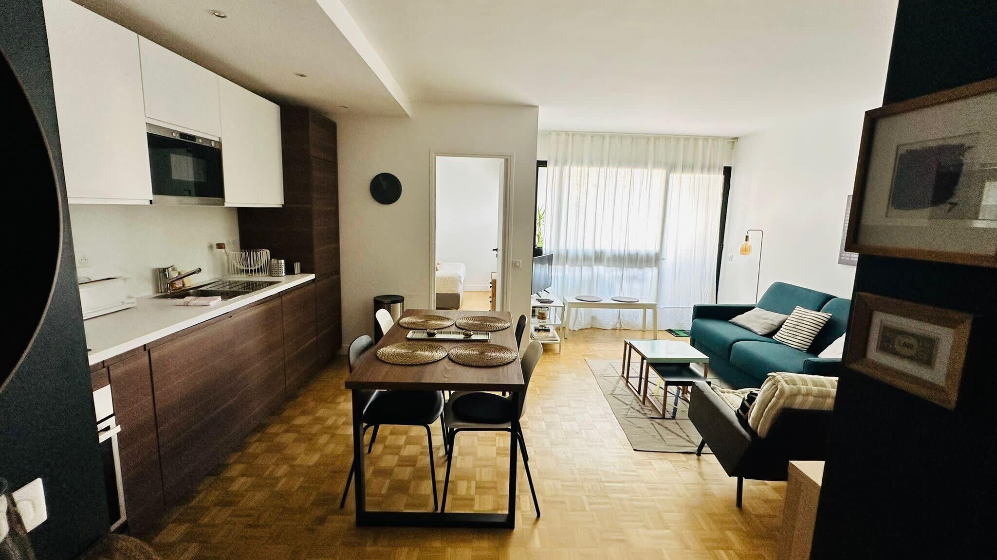 Ein modernes Apartment mit Küche, Essbereich und Wohnzimmer.