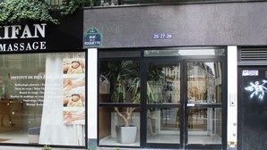A massage parlor with a large window displaying various services.