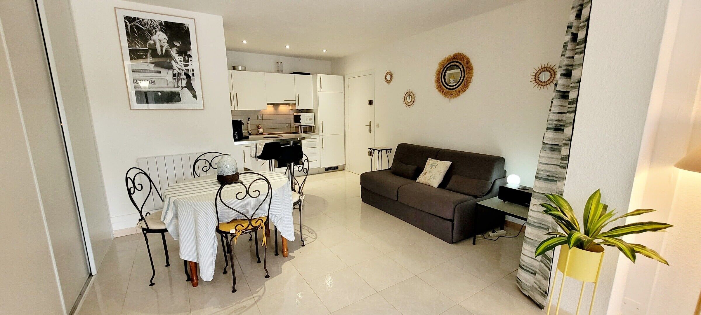 A compact living space with a dining area, kitchenette, and a sofa.