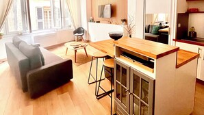 Een moderne woonkamer met een bank, een eettafel en een keuken met een bar.