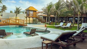 A pool area with lounge chairs, a wooden deck, and a small tower structure.