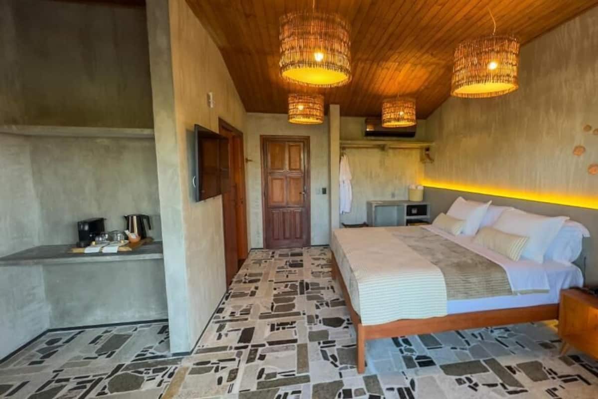 A bedroom with a bed, bedside table, and a wall-mounted TV.
