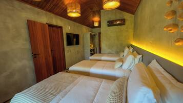 A hotel room with two beds, wooden ceiling, and a wall-mounted light fixture.