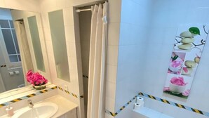 A modern bathroom with a white sink, mirror, and toilet. - Rooms Flor (Barcelona)