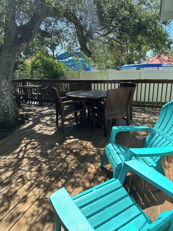 A wooden deck with a table and chairs, surrounded by a wooden fence.