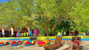 A beach with sun loungers, colorful inflatable toys, and a person relaxing. - Arenzo Beach Resort Calatagan Batangas (Calatagan)