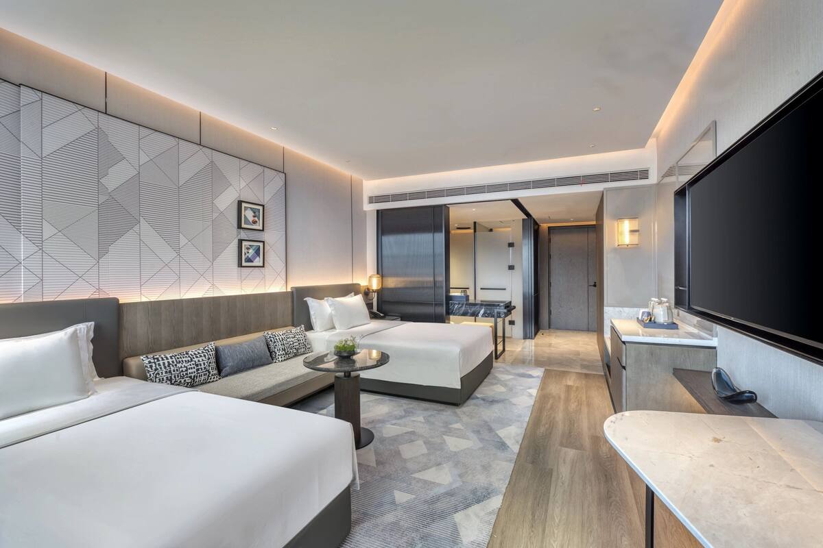 Une chambre d’hôtel moderne équipée d’un grand lit, d’un canapé, d’un bureau et d’une télévision.