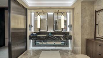A modern bathroom with a large mirror, a marble countertop, and a bench.