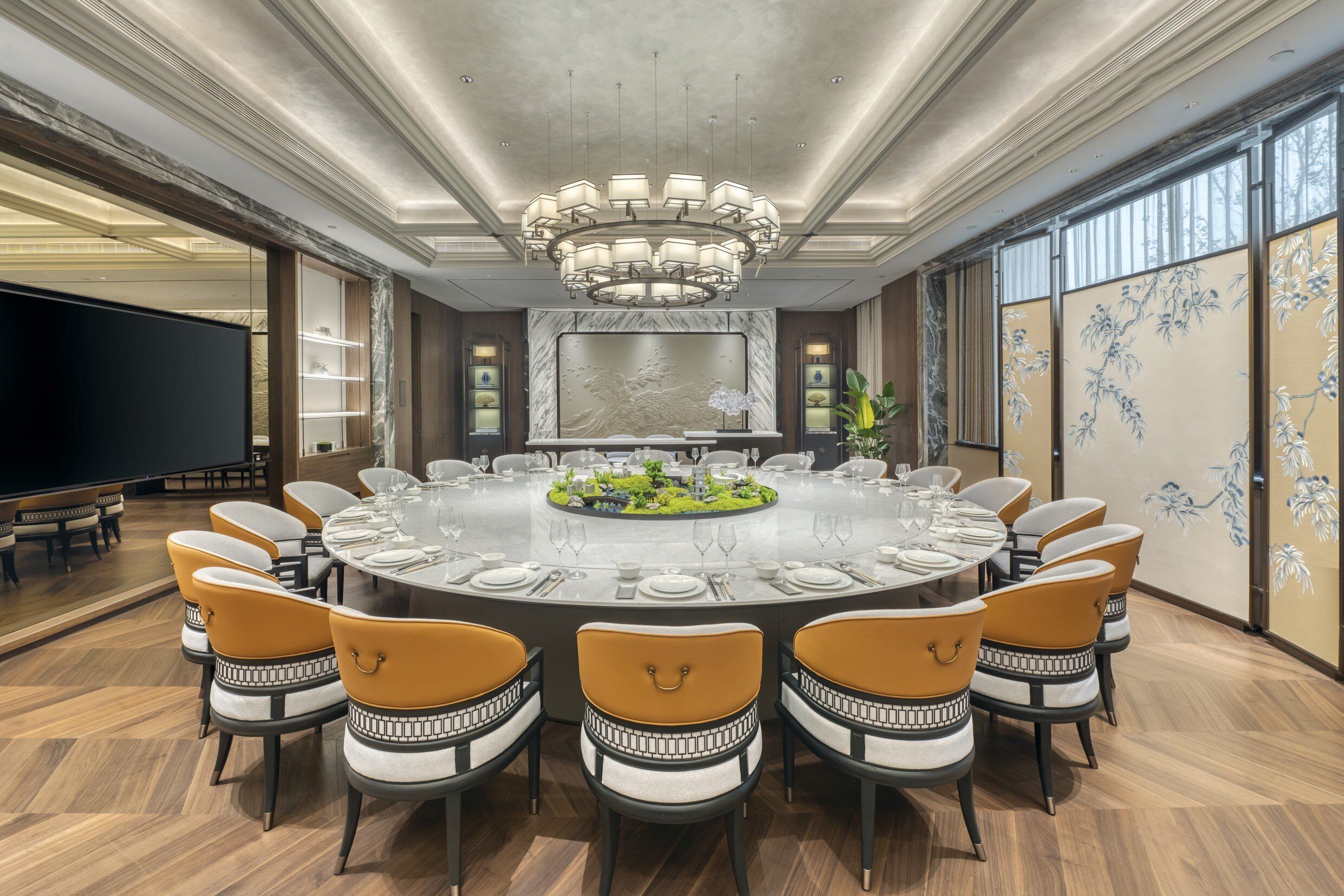 A conference room with a round table, chairs, and a chandelier.