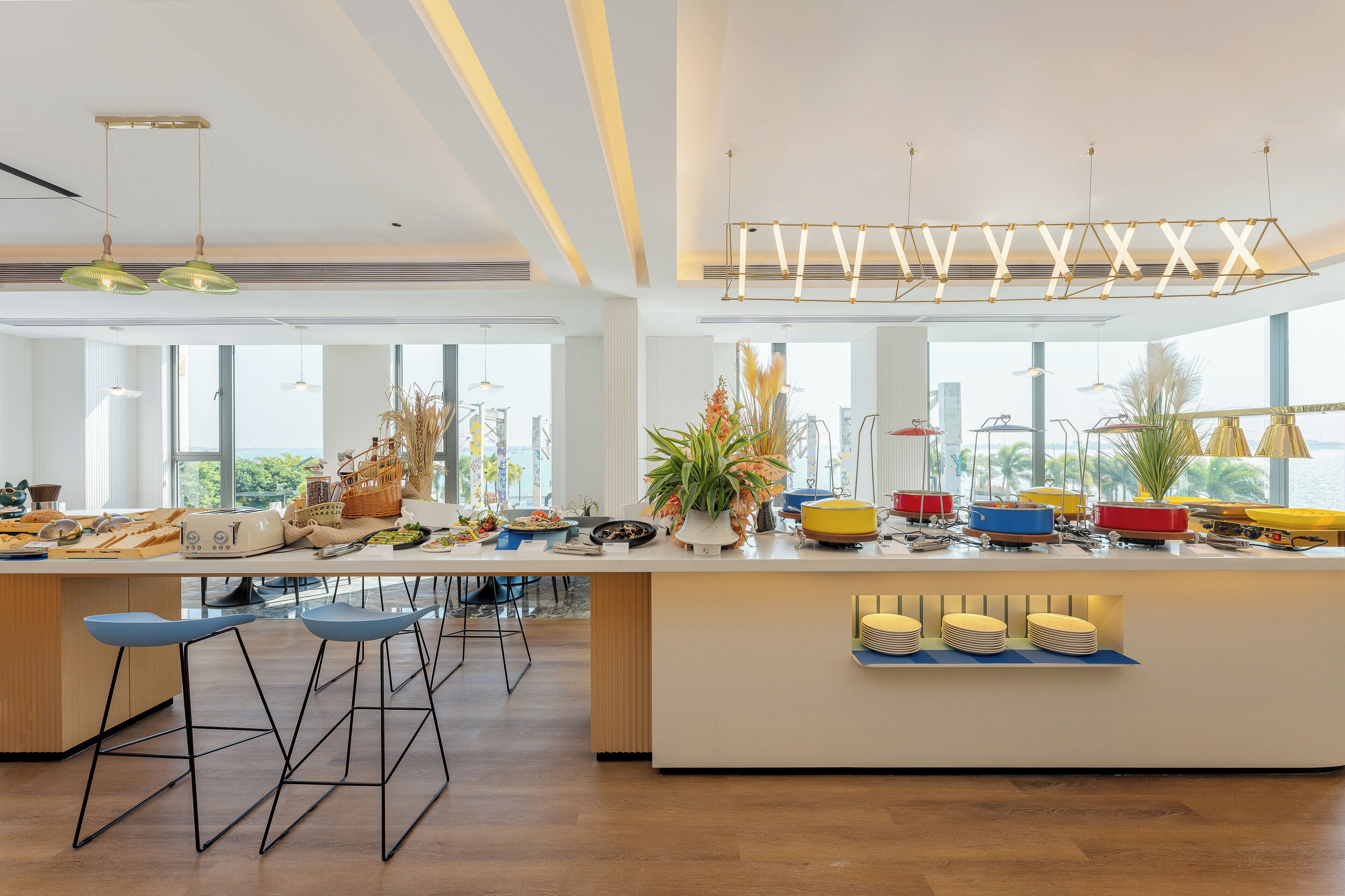 A modern kitchen with a central island, bar stools, and a variety of kitchen appliances and utensils.
