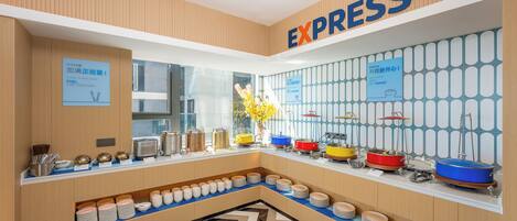 Ein Buffetbereich mit verschiedenen Speisen und Besteck, ein Schild mit der Aufschrift "EXPRESS" sowie eine Wand mit Musterung.