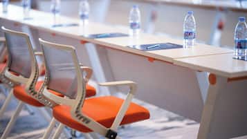 A conference room with a long table, chairs, and water bottles.