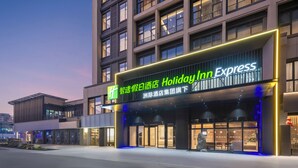 En Holiday Inn Express bygning med en moderne facade, store vinduer og en markant indgang.