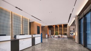 A modern reception area with a marble reception desk, seating area with sofas, and a large glass wall. - Holiday Inn Express Changzhou Henglin by IHG (Changzhou)