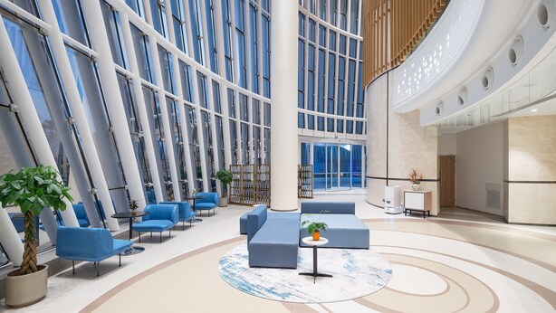 A modern lobby with blue seating, large windows, and a central column.