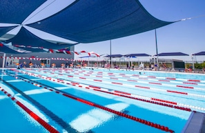 A swimming pool with multiple lanes, shaded by large canopies, and surrounded by spectator areas. - Staybridge Suites Ocala-near Equestrian-Aquatics by IHG (Ocala)