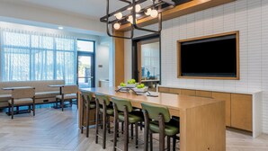 Une cuisine moderne dotée d’un grand îlot central, de tabourets de bar et d’une grande fenêtre.