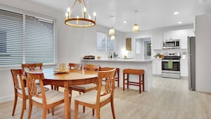Una cocina moderna con armarios blancos, electrodomésticos de acero inoxidable y una isla central.