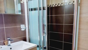 A modern bathroom with a glass-enclosed shower, a wooden vanity with a sink, and a tiled floor. - 200m from ski slopes, 1st floor, balcony, tv, 26m², Montalbert (La Plagne)