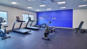 A gym with treadmills, stationary bikes, and a rowing machine.