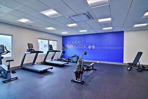A gym with treadmills, stationary bikes, and a rowing machine.