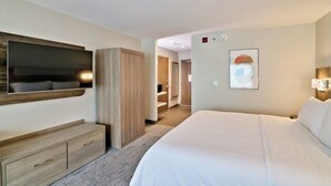 A hotel room with a large bed, a TV mounted on the wall, a wardrobe, and a bathroom visible through an open door. - Holiday Inn Express & Suites St. Vincent - Grenadines by IHG (Diamond)
