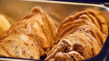 A tray of pastries, likely croissants, with a dusting of powdered sugar.