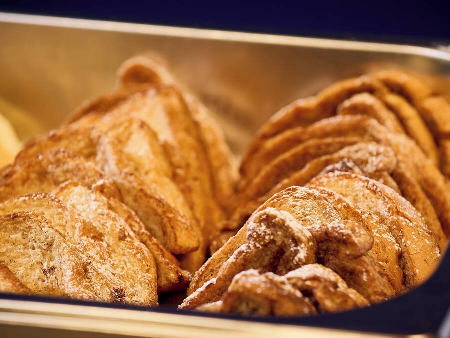 A tray of pastries, likely croissants, with a dusting of powdered sugar.