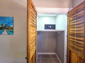 A bathroom with wooden doors, a towel rack, and a painting of a beach scene.