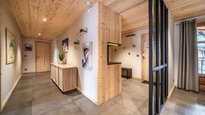 A modern interior with wooden panel walls, a reception desk, and a view through a glass door. - 1st floor, view village, balcony, fireplace or stove, parking, tv, ski locker, 97m², Morzine (Morzine)