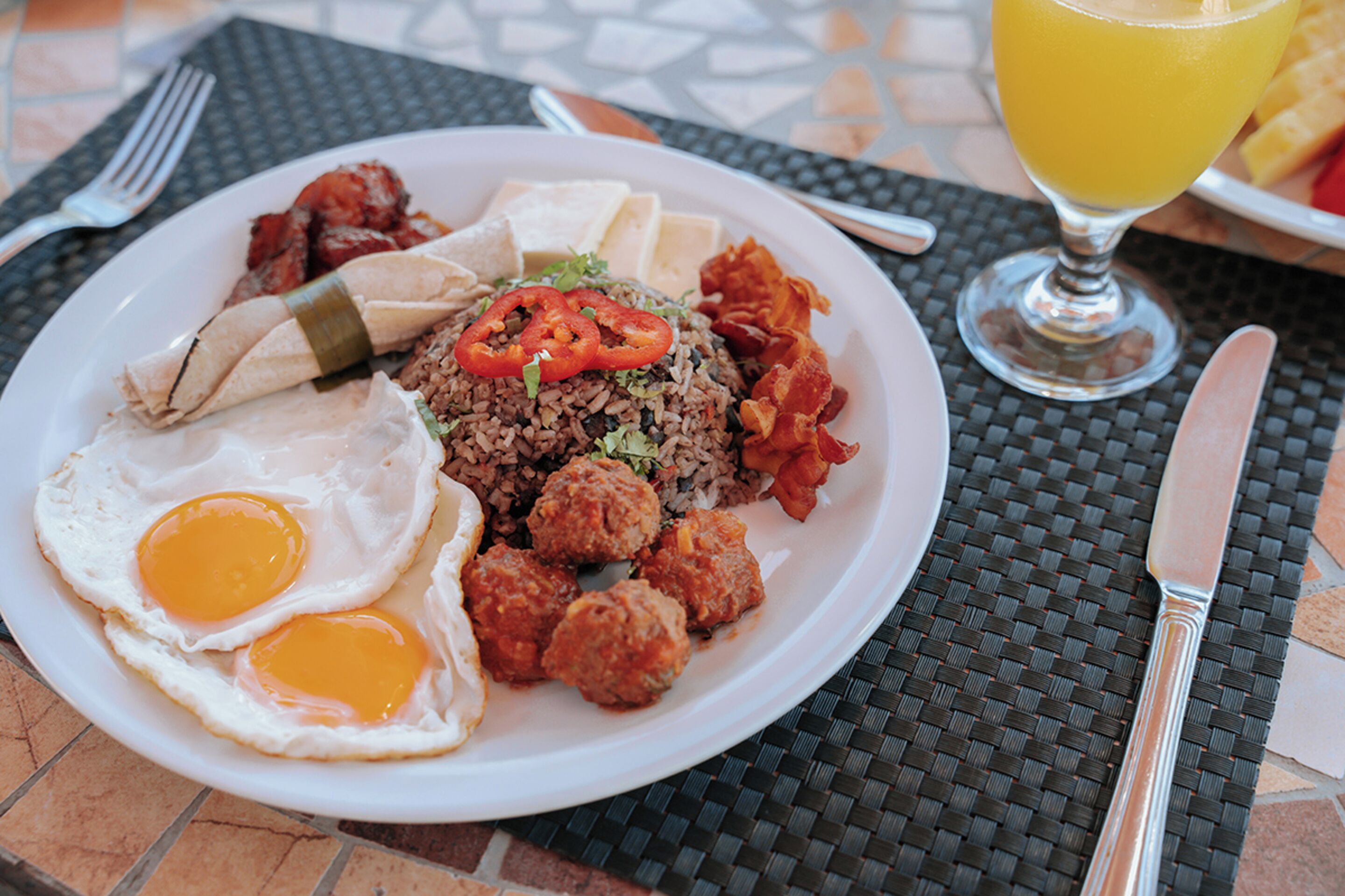 Une assiette de nourriture composée d’œufs, de riz, de boulettes de viande et de légumes.