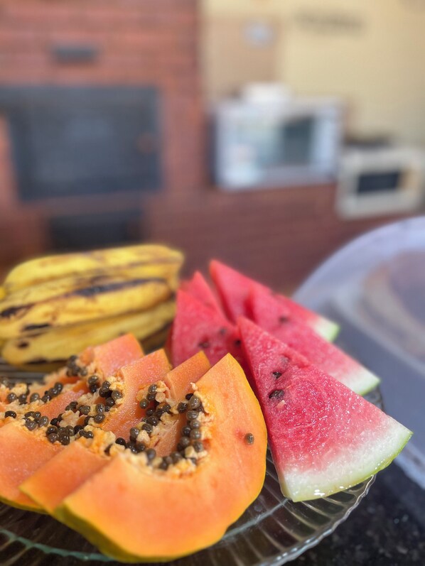 En tallrik med skivad frukt, inklusive papaya och vattenmelon.