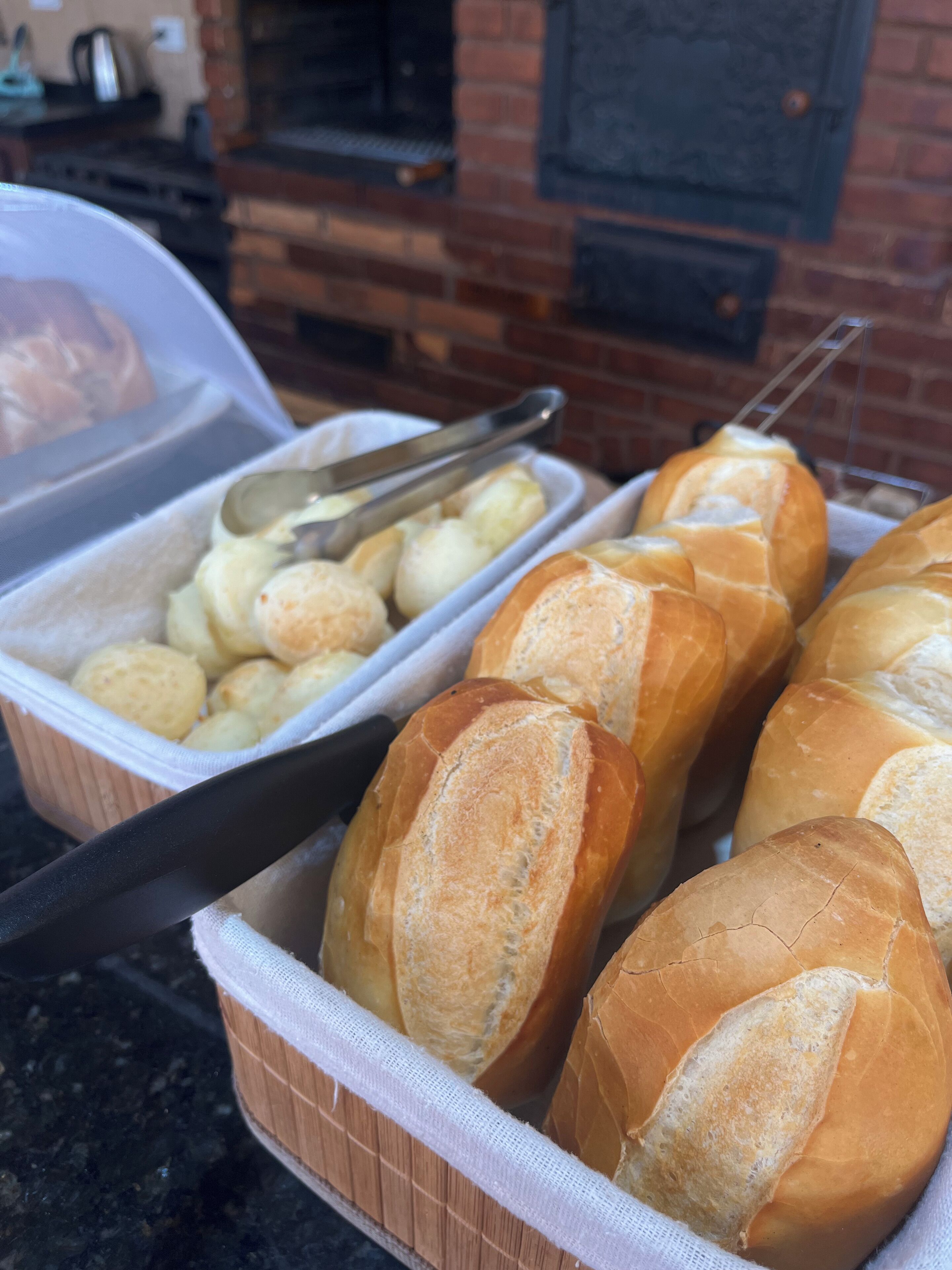 Un bufé con pan y pasteles en cestas.