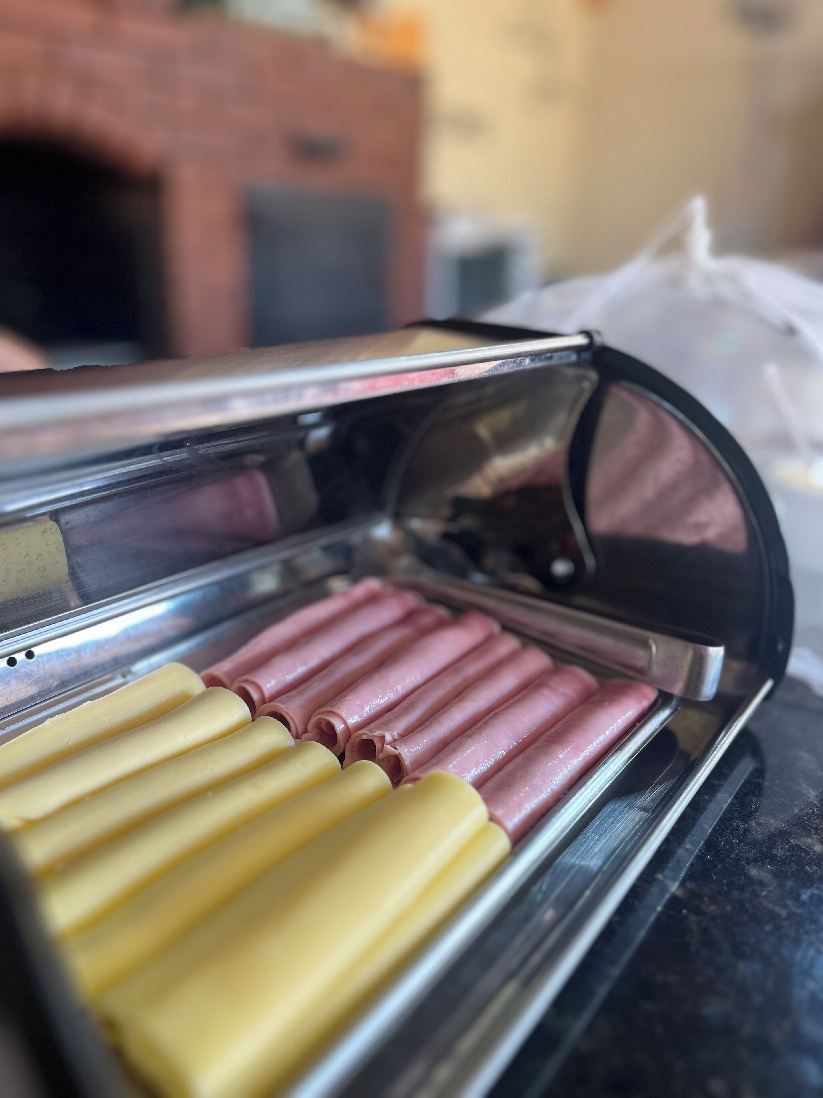 On peut voir clairement une vitrine réfrigérée où sont présentés des aliments, disposés de manière ordonnée.