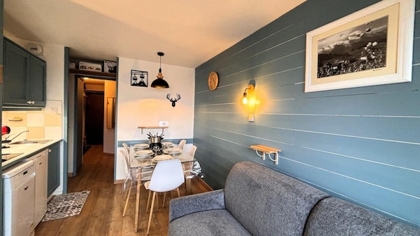 A compact living space with a dining area, a sofa, a kitchen, and a wall-mounted light fixture. - 200m from resort center, 1st floor, balcony, tv, ski locker, 25m², Avoriaz (Avoriaz)