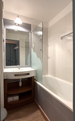 A bathroom with a white sink, a mirror, and a glass-enclosed shower. - 200m from resort center, 1st floor, balcony, tv, ski locker, 25m², Avoriaz (Avoriaz)