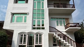 A multi-story building with a central staircase, multiple windows, and a stone foundation. - Shesh Bagh Boutique Homestay (Srinagar)
